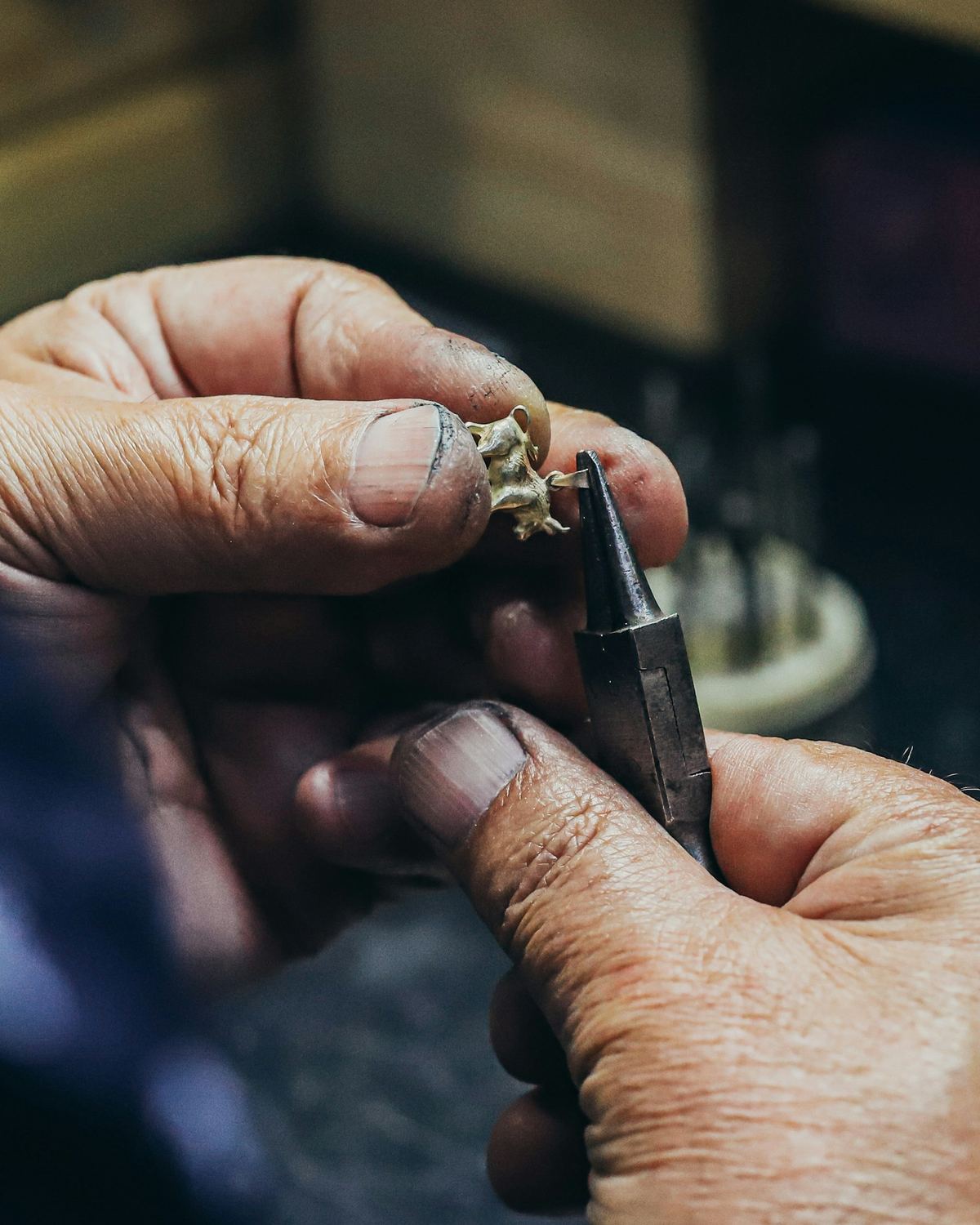 Jeweller's hands holding a ring and setting tool at the bench